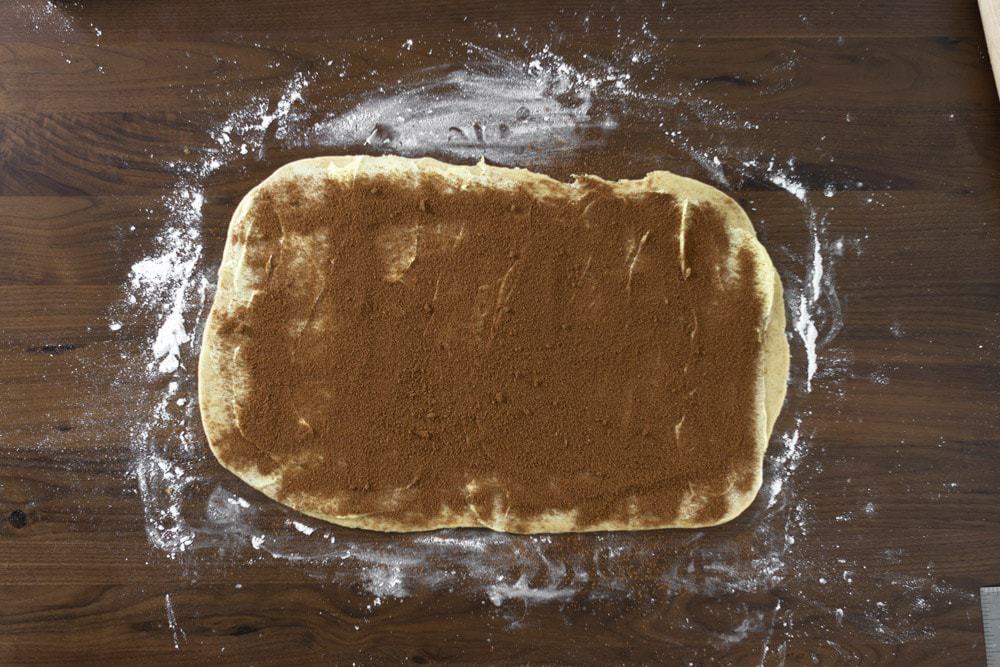 cinnamon sugar sprinkled over king cake dough