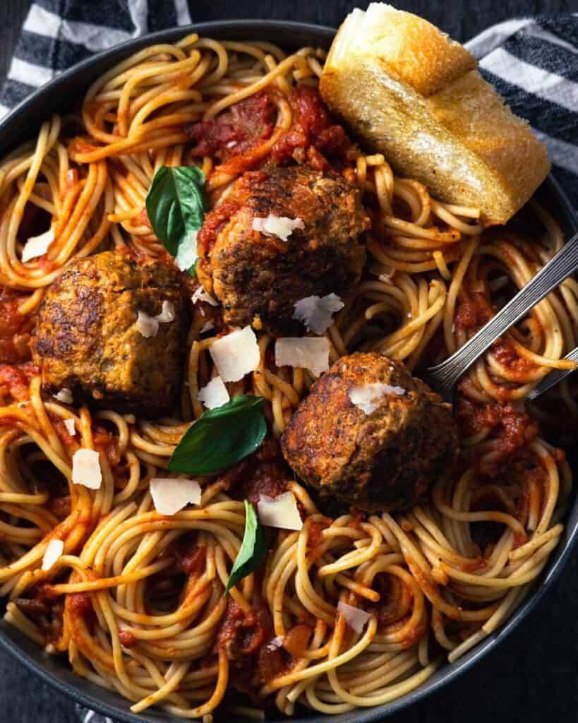 up close bowl of meatballs and spaghetti with marinara