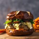 up close turkey burger with caramelized onions, brie, sun dried tomato mayo, and arugula