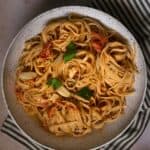 a large white bowl of baked goat cheese and tomato pasta