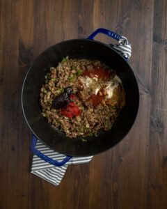 browned ground chuck, spices, sautéed vegetables, and tomato paste in a dutch oven