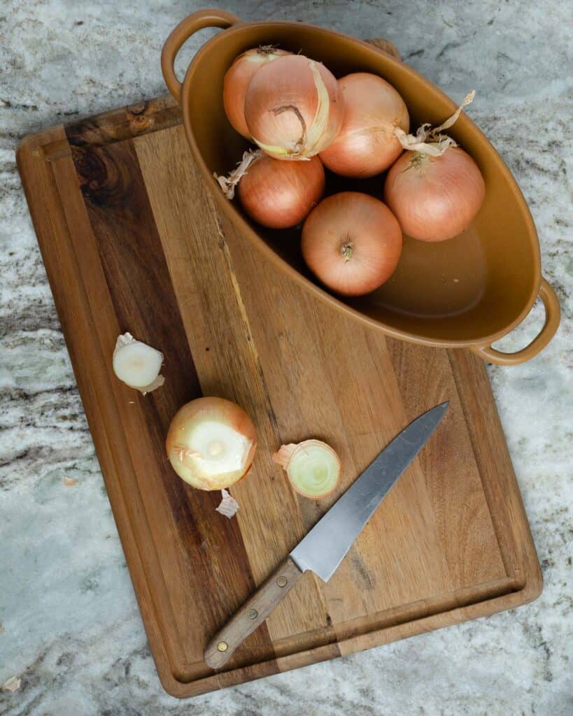 an onion on a cutting board with the top and bottom sliced off