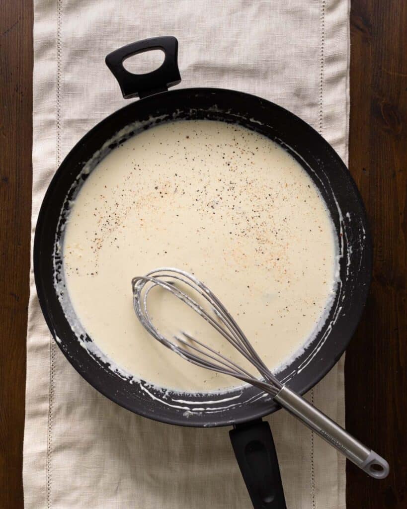 roasted garlic alfredo sauce with pepper in a sauce pan