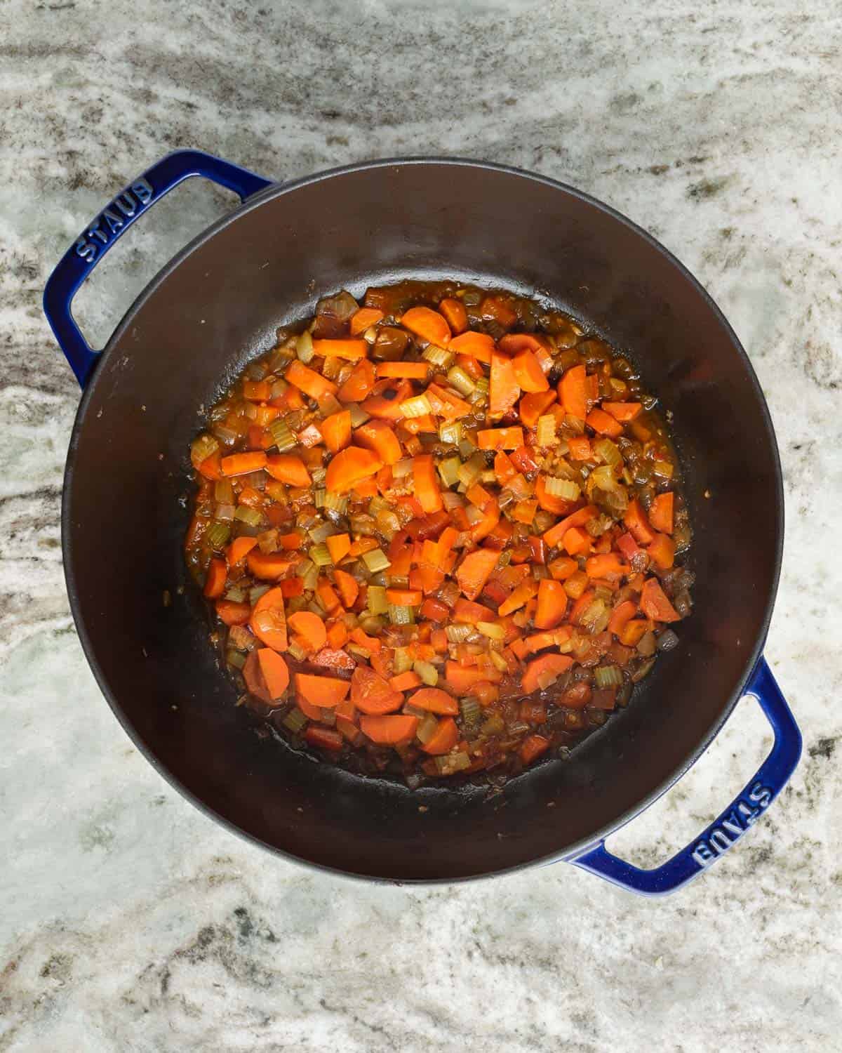 A pot with caramelized carrots, onions, celery and peppers deglazed with wine.