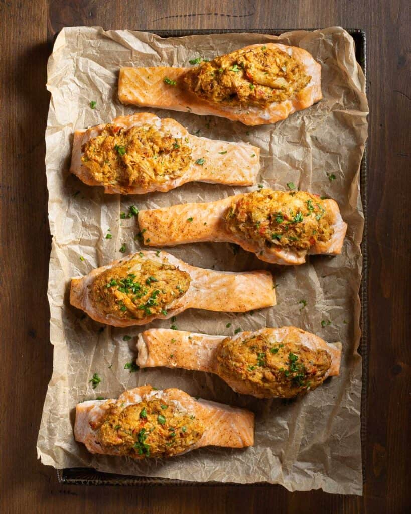Cajun crab stuffed salmon on a parchment lined baking sheet after baking.