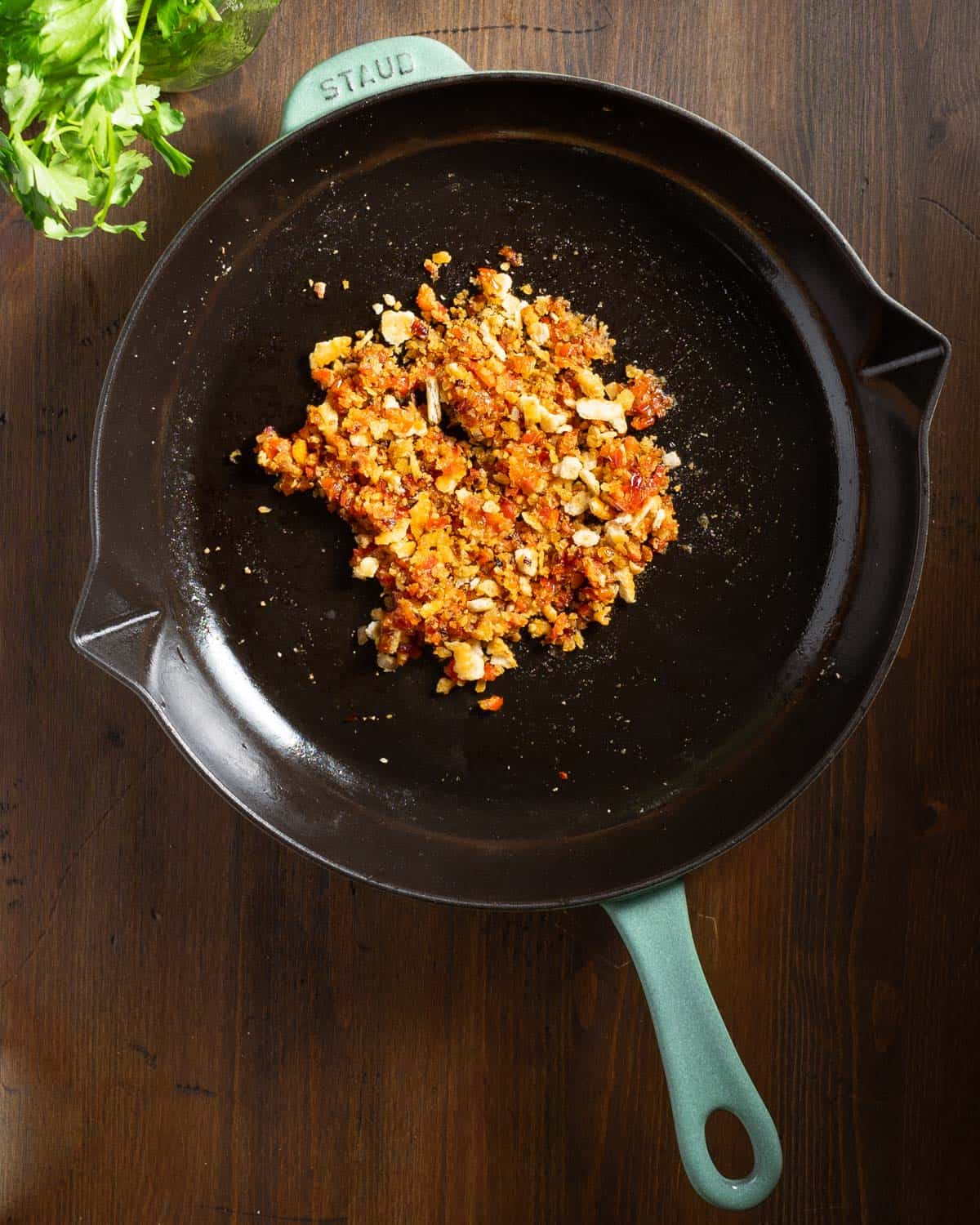 Sautéed shallots and red peppers with cracker crumbs in a skillet.