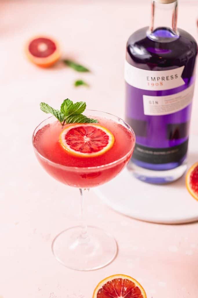 a blood orange gin fizz cocktail in a cocktail glass with empress gin.