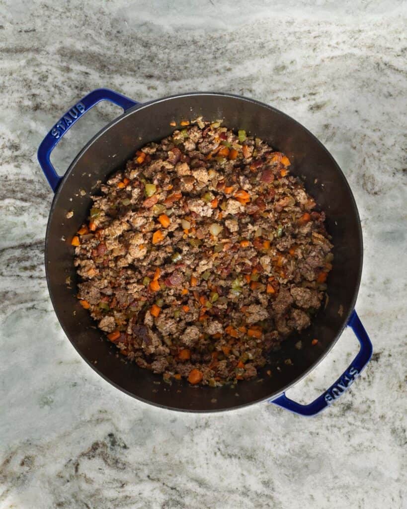 Ground chuck and mirepoix in a large pot.