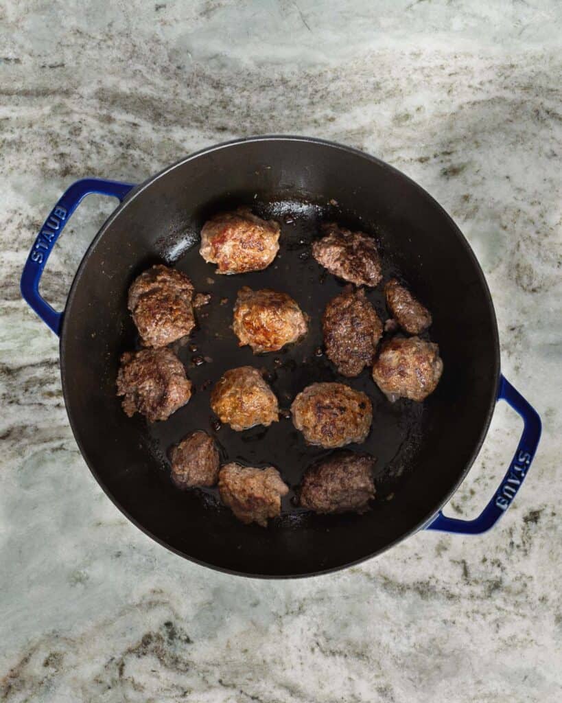 searing meatballs in a large pot
