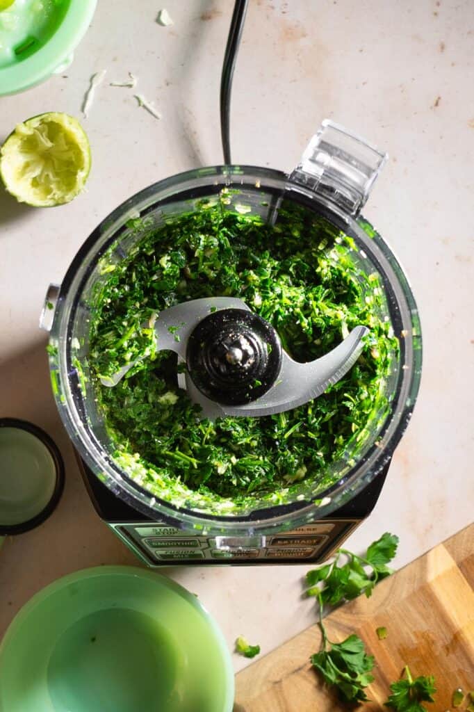 Chimichurri ingredients in a food processor after pulsing.