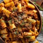 A bowl of short rib ragu rigatoni with fresh herbs.