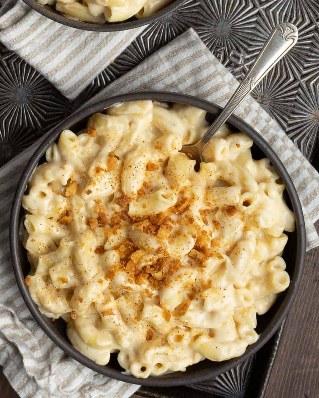 A bowl of creamy 4 cheese mac and cheese with a spoon.