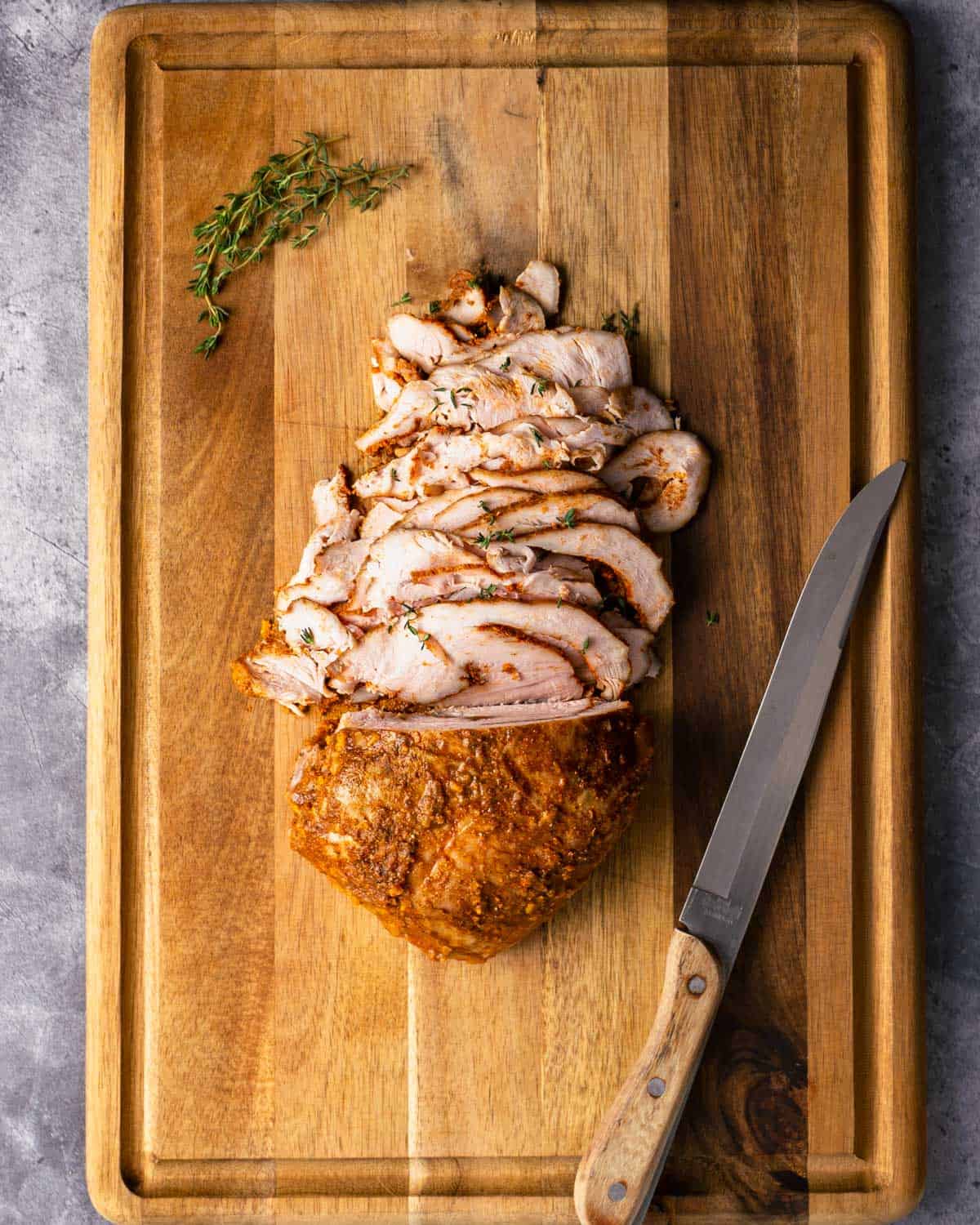 Sous vide cajun turkey breast freshly sliced on a cutting board.