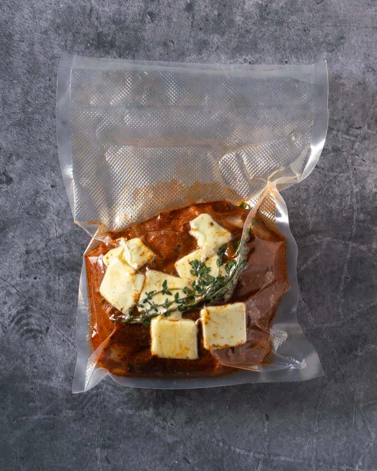 Turkey breast with cajun spices, butter, and thyme in a vacuum sealed bag.