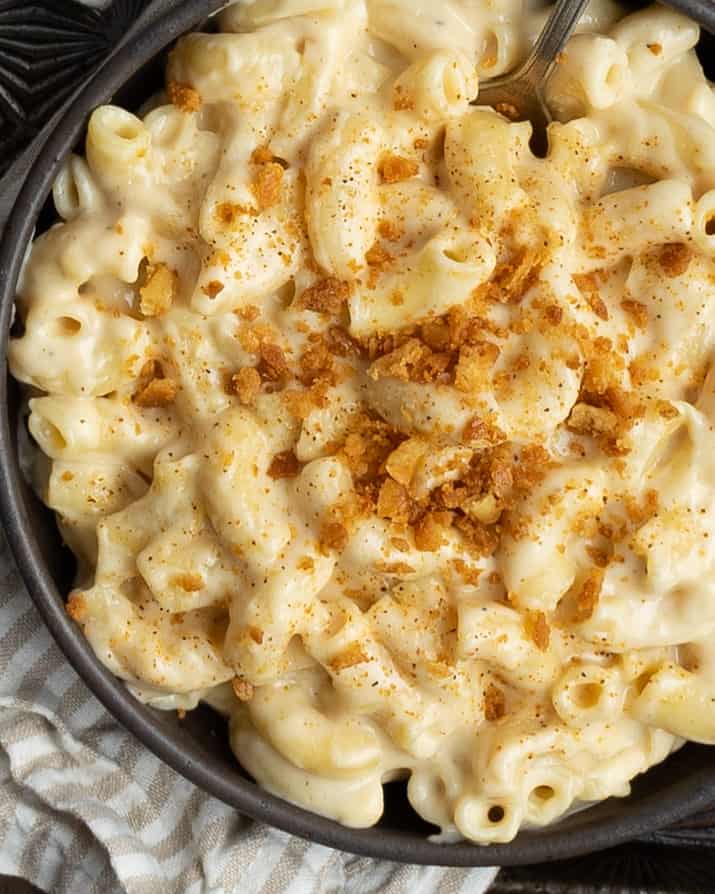 Up close bowl of mac and cheese with buttered cracker crumbs.