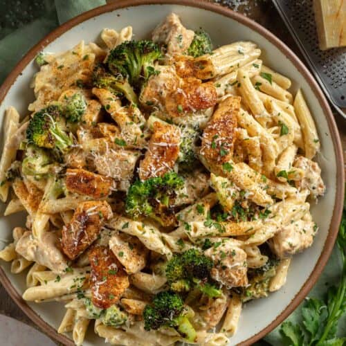 Bowl of Cajun Chicken and Broccoli Alfredo topped with parsley and parmesan.