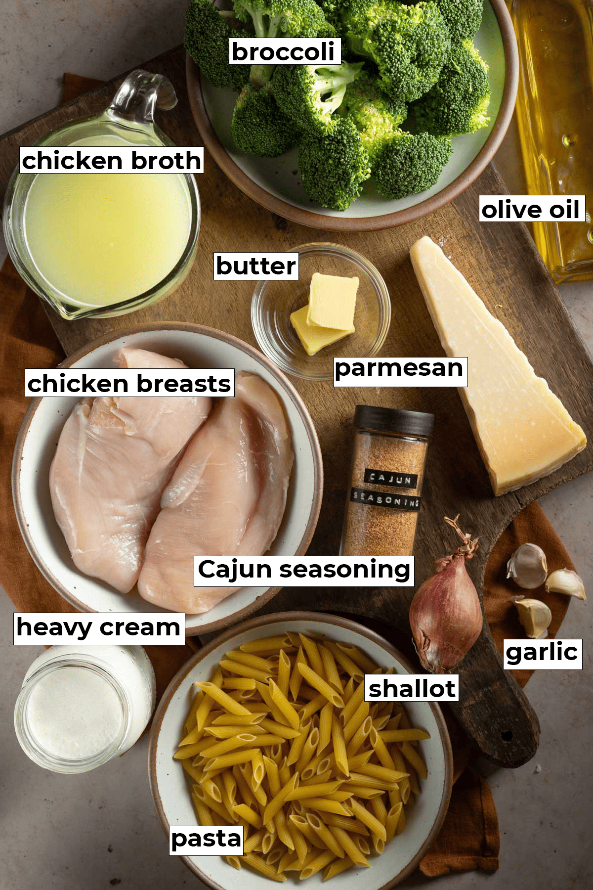 Labeled ingredients for Cajun Chicken and Broccoli Alfredo on a cutting board.