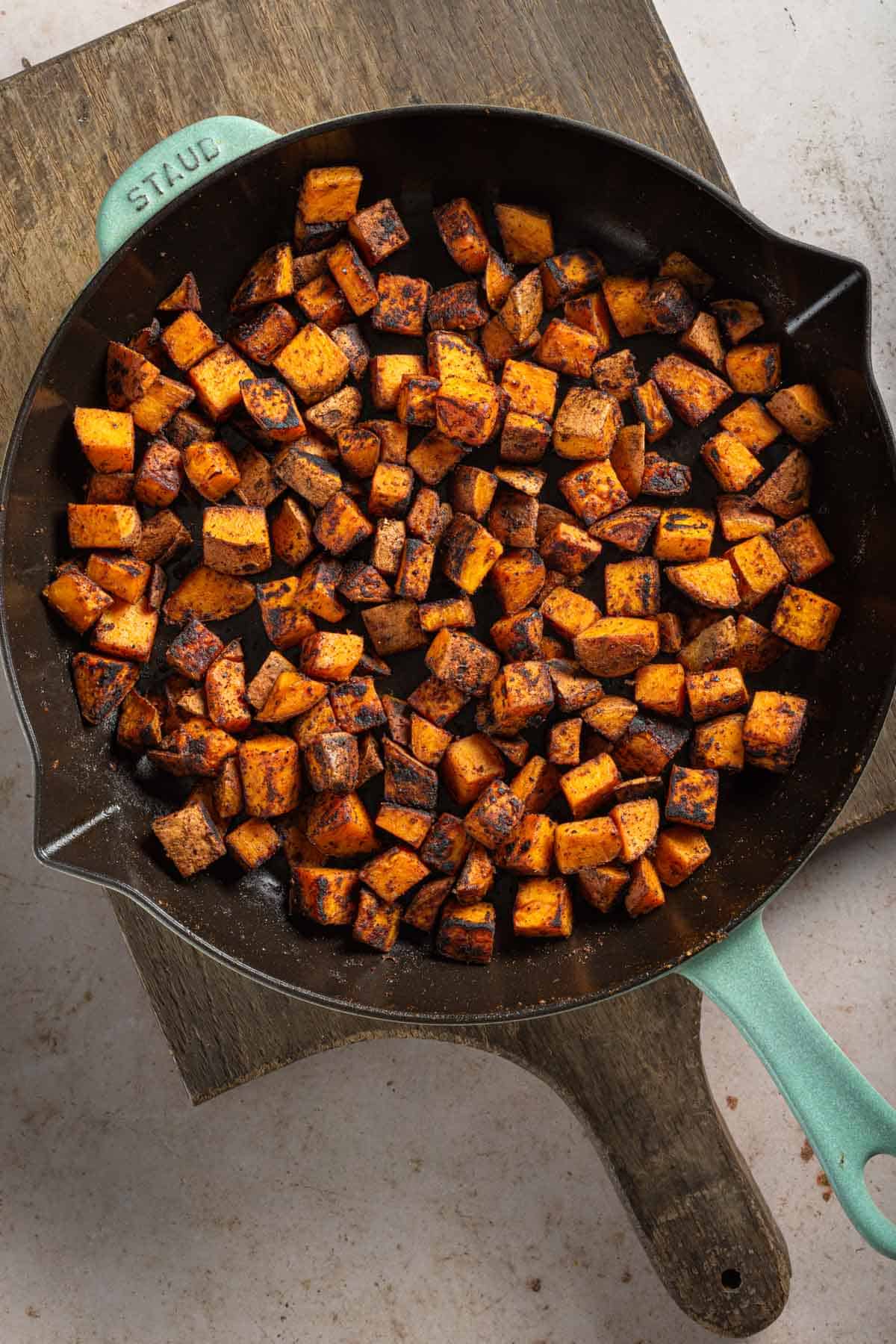 Sautéed sweet potatoes in a skillet.