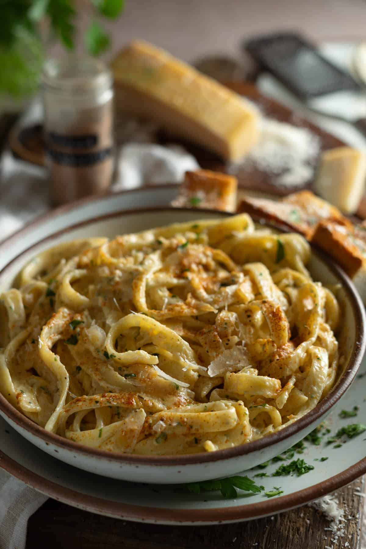 Side view of a bowl of cajun alfredo sauce.