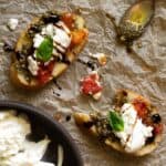 Burrata bruschetta with roasted tomatoes, balsamic glaze, and pesto.