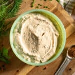 A bowl of homemade cajun ranch sauce with cajun seasoning and fresh herbs.