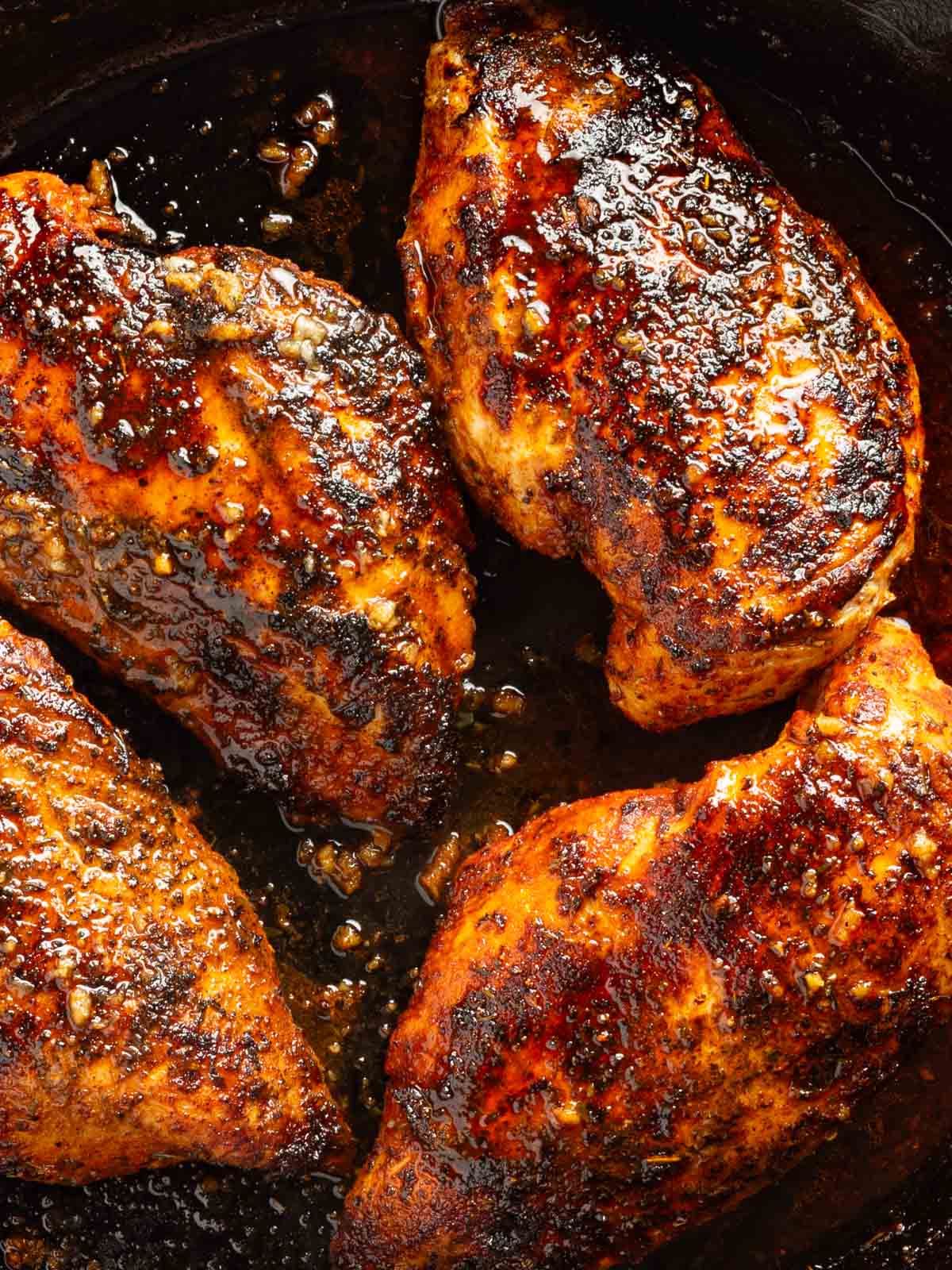 Up close blackened chicken breasts topped with garlic butter.