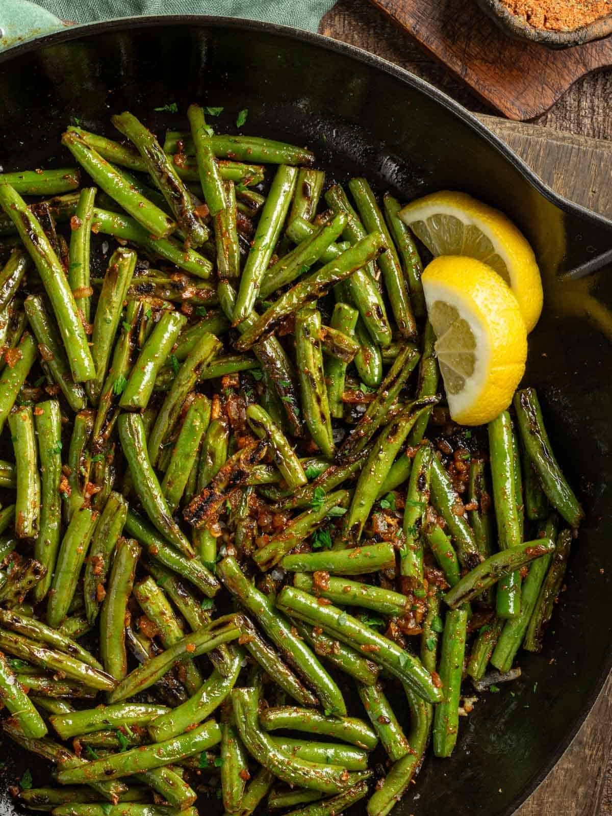 A cast iron skillet with cajun blackened green beans.