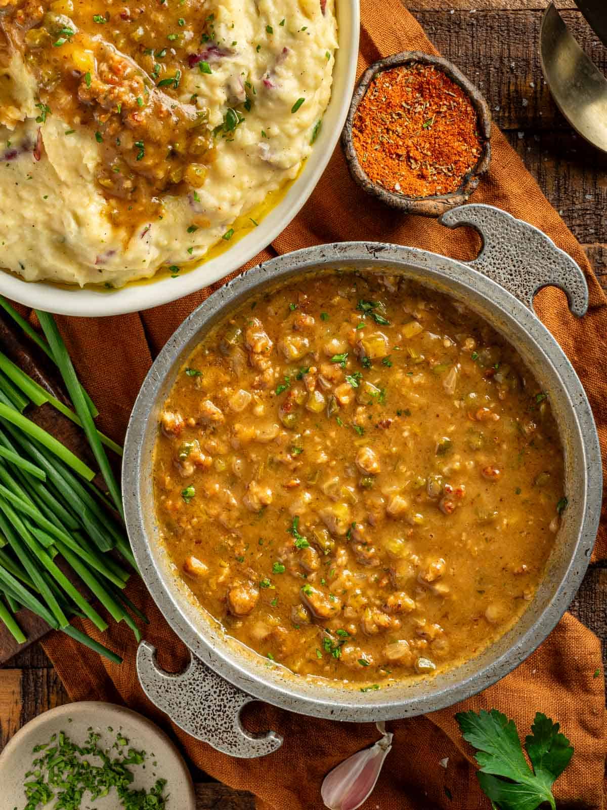 Cajun sausage gravy in a serving bowl with mashed potatoes.
