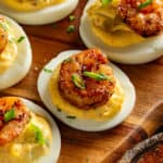 Cajun deviled egg on a platter topped with green onions.