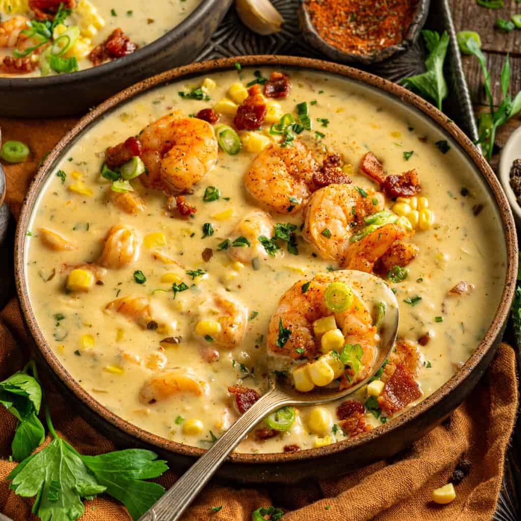 A bowl of Louisiana shrimp and corn bisque topped with bacon, green onions and parsley.