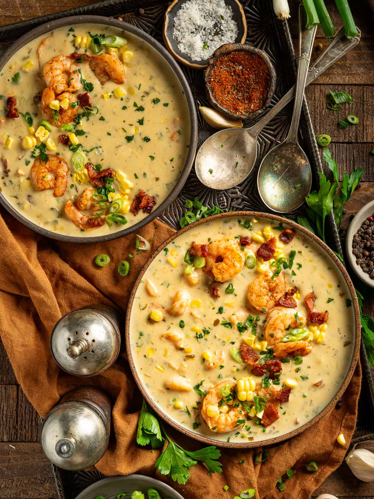 Two bowls of cajun shrimp and corn bisque with bacon.