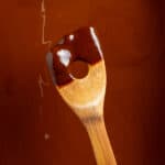 Dark roux for gumbo on a wooden spoon.