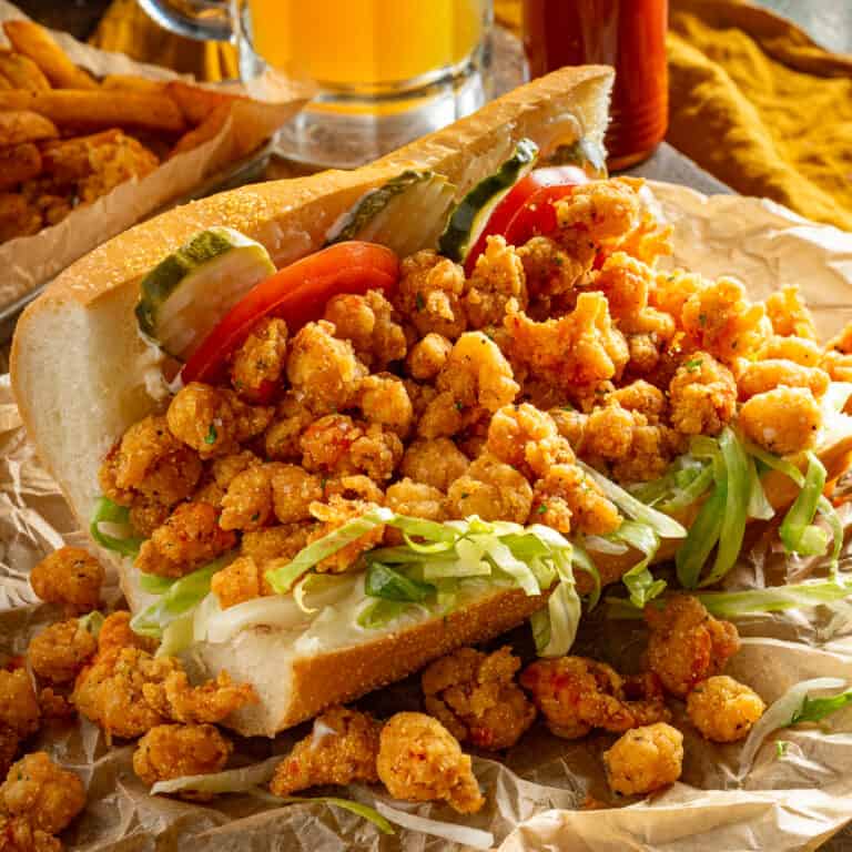 A fried crawfish poboy with lettuce, tomatoes, mayo, and pickles.