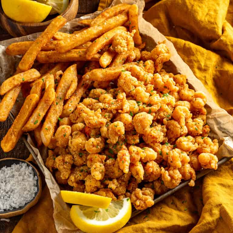 Cajun fried crawfish and french fries with lemon wedges.