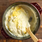 Stirring creamy grits with butter.