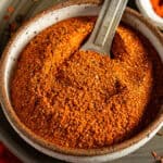 Cajun seasoning in a bowl with a measuring spoon.