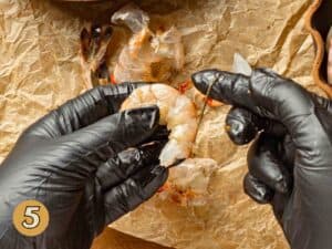 Pulling the vein off a shrimp.