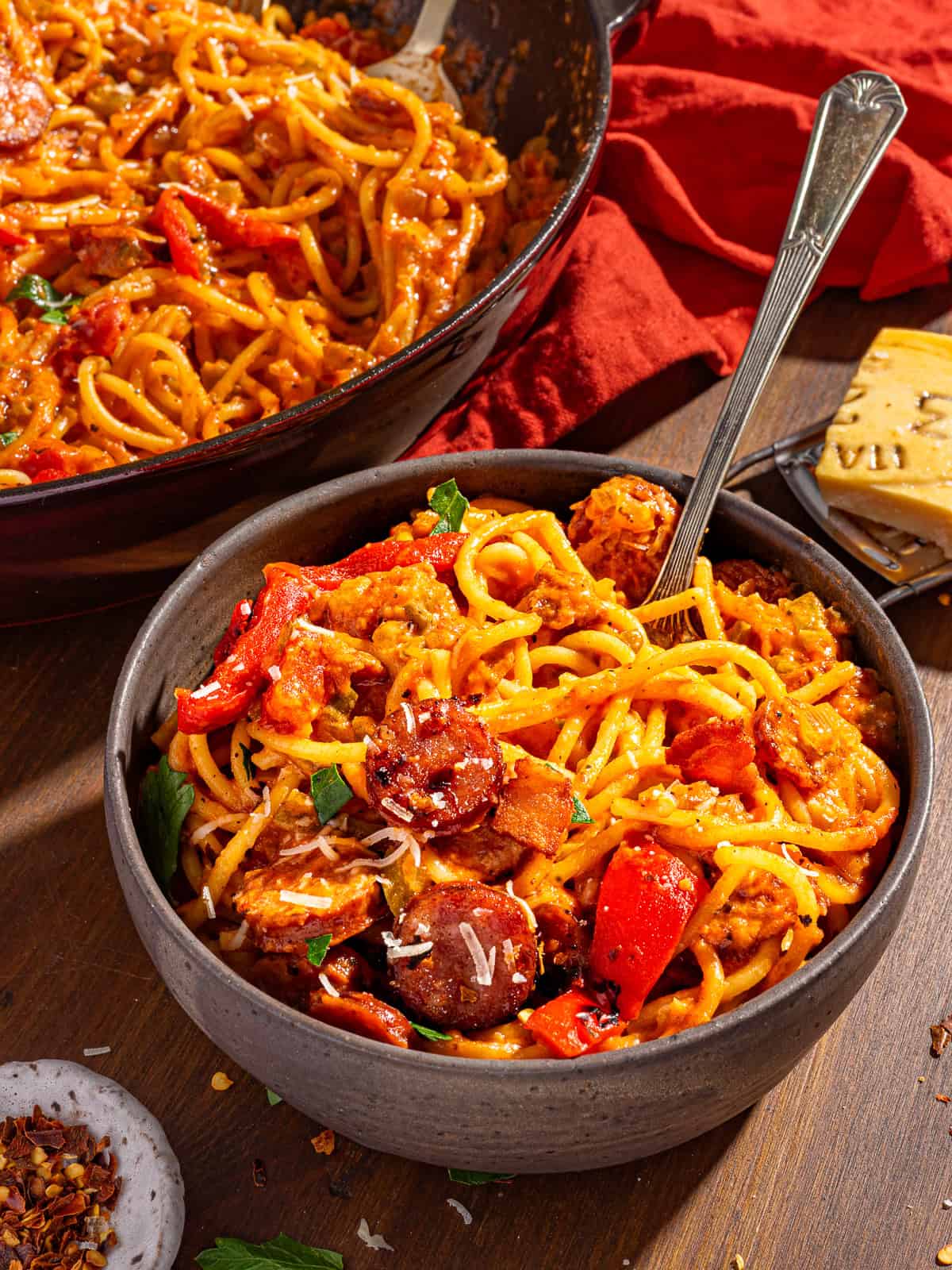 A bowl of cajun sausage spaghetti with a fork.