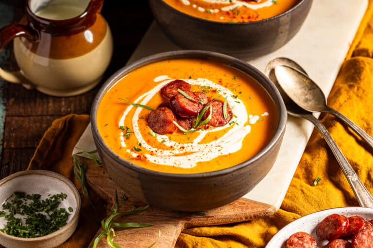 Butternut squash soup with goat cheese cream on a table.