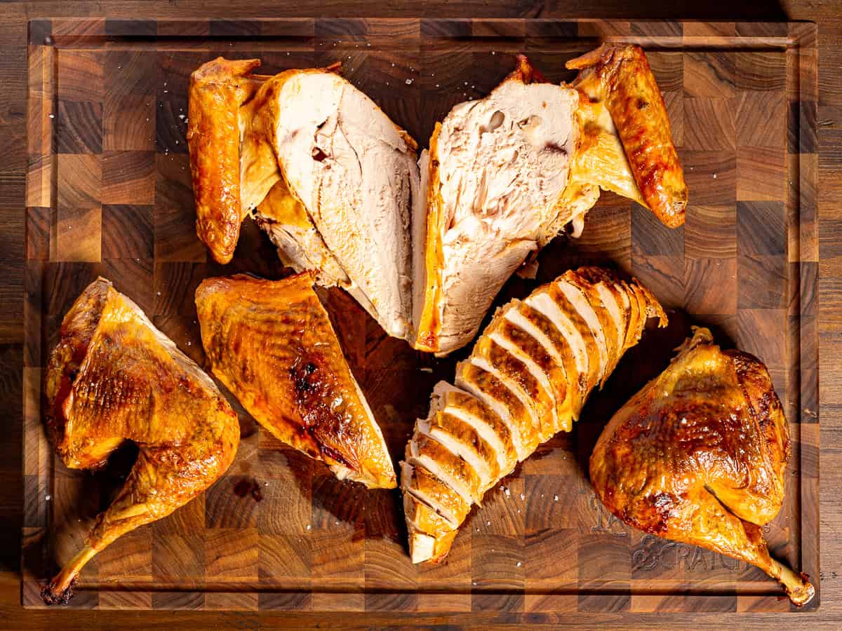 A carved spatchcock turkey on a cutting board.
