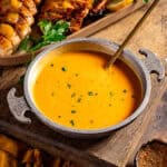 A bowl of cajun gravy with a spoon.